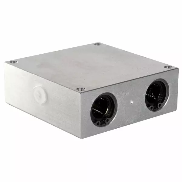 Rechteckiger Aluminiumblock mit zwei runden Öffnungen an der Vorderseite für Linearkugellager.