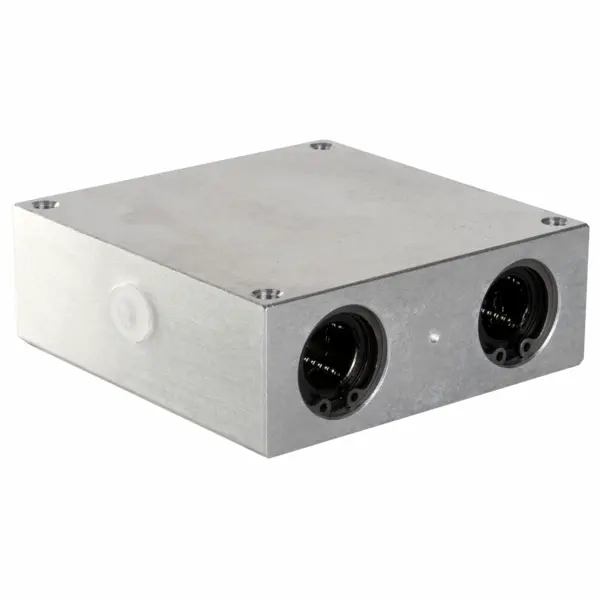 Rechteckiger Aluminiumblock mit zwei runden Öffnungen an der Vorderseite für Linearkugellager.