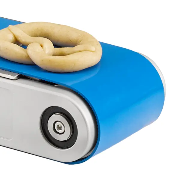 Ein blaues Transportband mit einer Teigbrezel darauf.