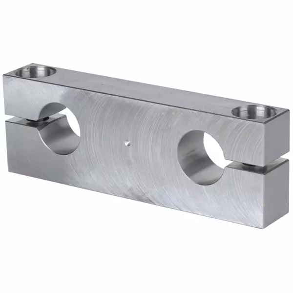 Aluminiumblock mit zwei großen, kreisförmigen Bohrungen in der Mitte und kleineren Bohrungen an den Ecken zur Befestigung.