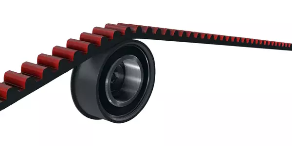 Ein Zahnriemenanschnitt mit roter Innenverzahnung läuft mit dem Riemenrücken über eine schwarze Rückenspannrolle.