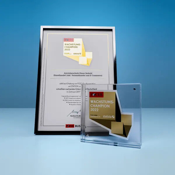 Urkunde und Glastrophäe des Wachstumschampion 2022 Awards von FOCUS Business und Statista, präsentiert in einem blauen Hintergrund.