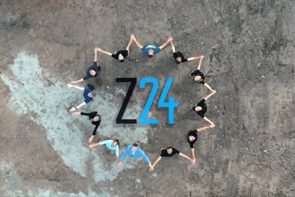 Zwölf Mitarbeitende bilden von oben die Form eines Zahnrads und schauen hinauf. In der Mitte ist das Z24-Logo zu sehen.