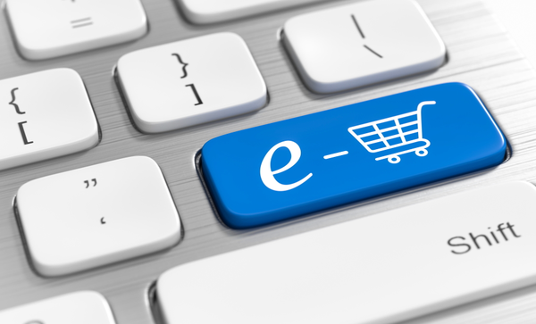 Blaue Computertaste mit der Aufschrift "e" und dem Symbol eines Einkaufswagens, eingebettet in eine Computertastatur.