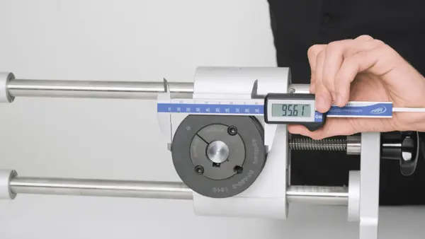 Hand misst mit einem digitalen Messschieber den Durchmesser einer montierten Riemenscheibe. Das Display zeigt 95,61 mm an.