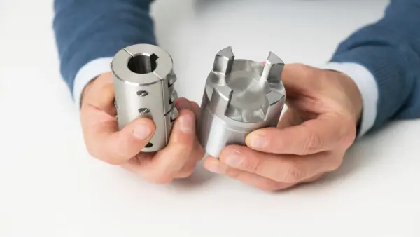 Zwei glänzende Edelstahlkupplungsnaben werden von einer Person in den Händen gehalten.