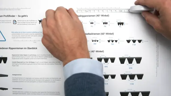 Zwei Hände messen mit einem Lineal die Maßstabsleiste auf dem Z24 Profilfinder, um die korrekte Skalierung für Keilrippenriemen- und Kraftbandprofile zu überprüfen.