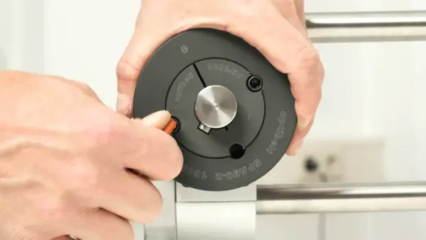 Eine Person zieht mit einem Inbusschlüssel die Schrauben einer montierten Keilriemenscheibe mit Taperbuchse auf einer Welle fest