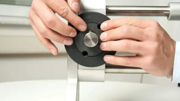 Nahaufnahme, wie eine Person die Keilriemenscheibe mit Taperbuchse auf der Welle ausrichtet und fixiert.