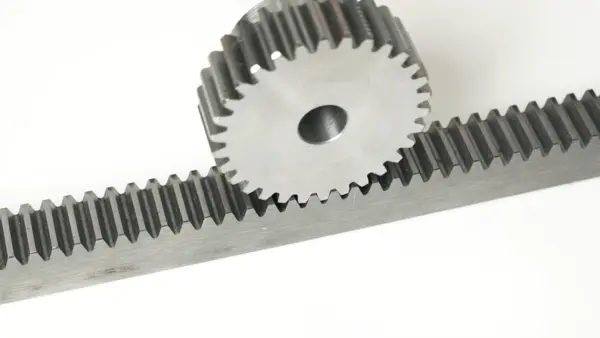 Nahaufnahme eines Metallzahnrads im Eingriff mit einer Zahnstange zur linearen Kraftübertragung.